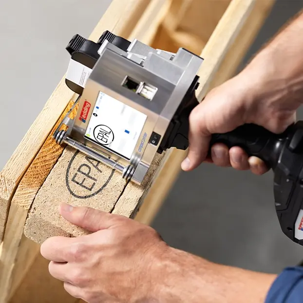 An image of a portable handheld thermal inkjet printer coding an epal logo onto a wooden pallet