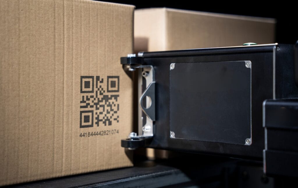 An image of a large charcater inkjet printing a QR code onto a cardboard box