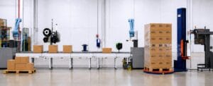 An image of a warehouse setting with a production line showing automtion equipment like a labeller, palletiser and stretch wrapper